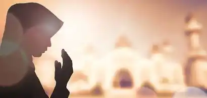 Personne priant devant un bâtiment religieux.