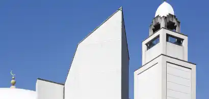 Minaret moderne sous ciel bleu clair.